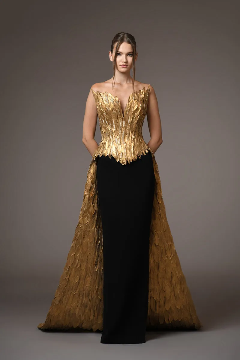 A golden feather corseted bustier with a dramatic overskirt, paired with a silk black crêpe skirt